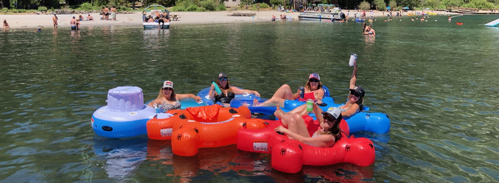 A group of friends on a lake float with Fluzzle Tubes and an interlocking floating Fluzzle Tube cooler. 