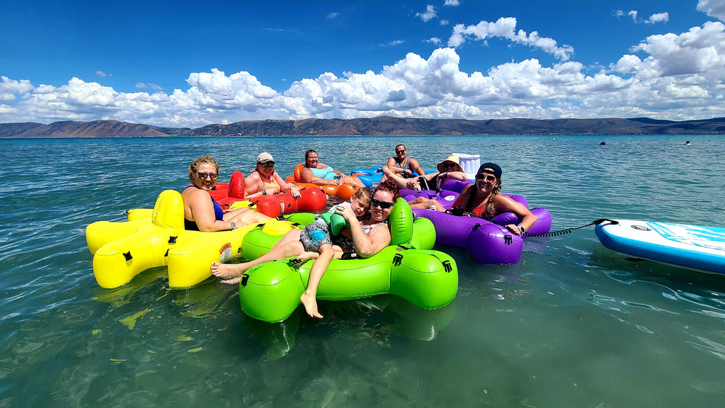 Family floating on a lake in interlocking puzzle shaped Fluzzle Tubes.  