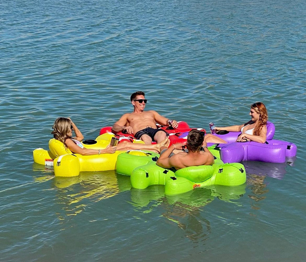 Group of friends floating on water in colorful Fluzzle Tube water float tubes. 